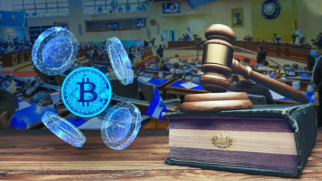 moneda de bitcoin entre monedas digitales junto a libro de leyes con bandera de El Salvador y martillo de juez, con asamble legislativa en el fondo