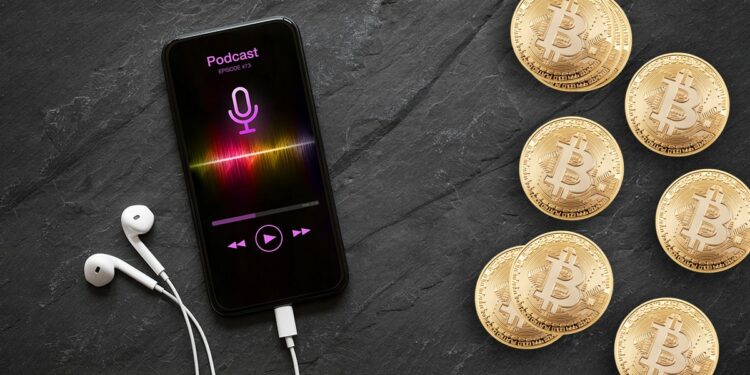 telefono conectado a audifonos con poscast reproduciendose en pantalla junto a monedas de bitcoin