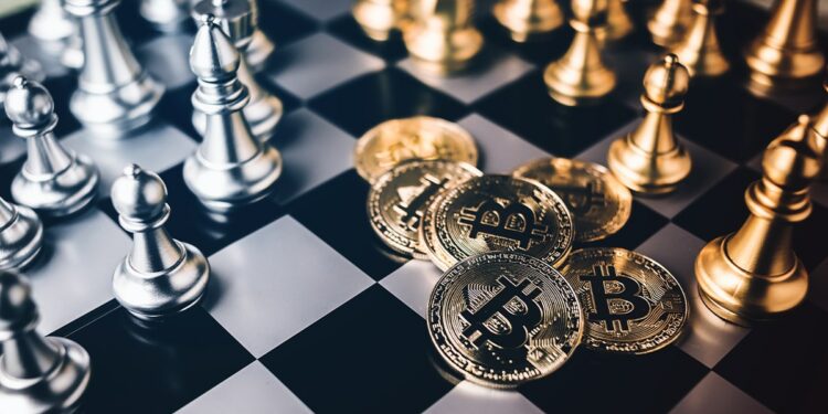 monedas de bitcoin junto a piezas de juego sobre tablero de ajedrez