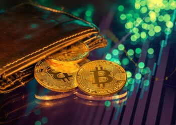 monedas de bitcoin saliendo de billetera sobre mesa de cristal con gráfico de precio alcista reflejado en la mesa