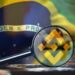 Lupa con logo de Binance sobre computadora con bandera de Brasil en el fondo