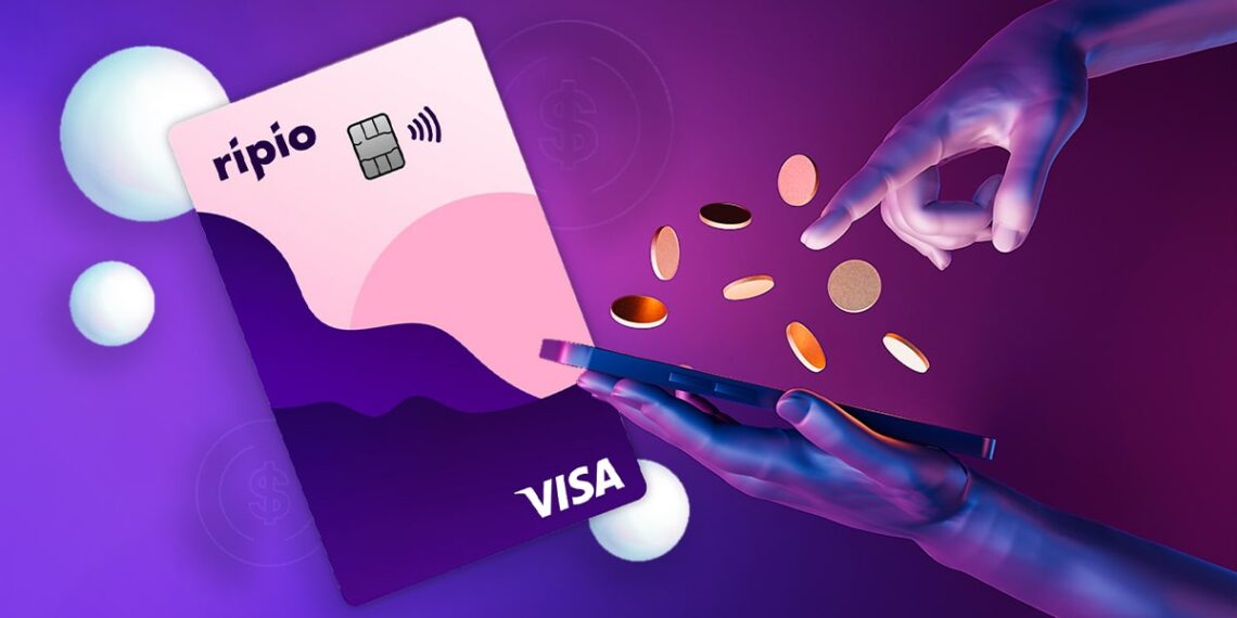 tarjeta visa de Ripio junto a manos con monedas digitales sobre teléfono móvil