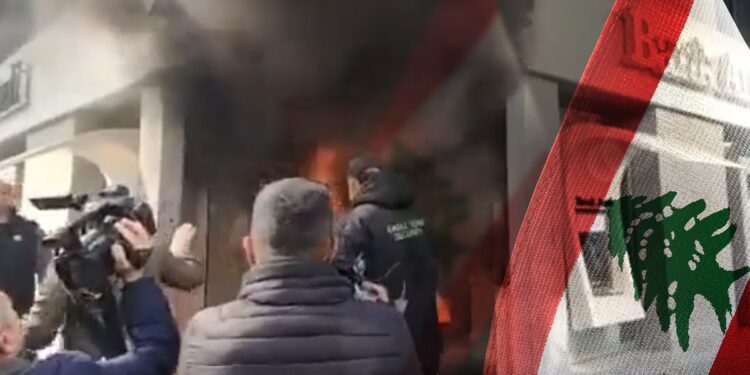 protestantes incendiando sede bancaris junto a bandera de Libano
