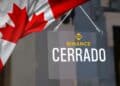 bandera de canada sobre letrero de Cerrado sobre puerta de cristal