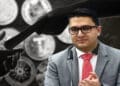 Joselit Ramirez junto a manos dándose dinero y criptomonedas de fondo.