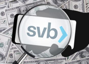 Logo Silicon Valley Bank detrás de una lupa con dolares de fondo.