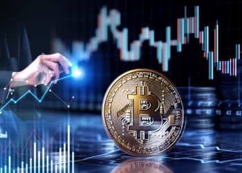 analista de mercado señalando grafico de precio junto a moneda de bitcoin con grafico de precio y monedas apiladas en el fondo