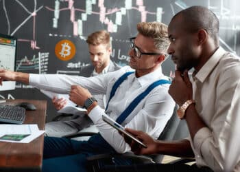 Analistas viendo el precio de bitcoin en alza.