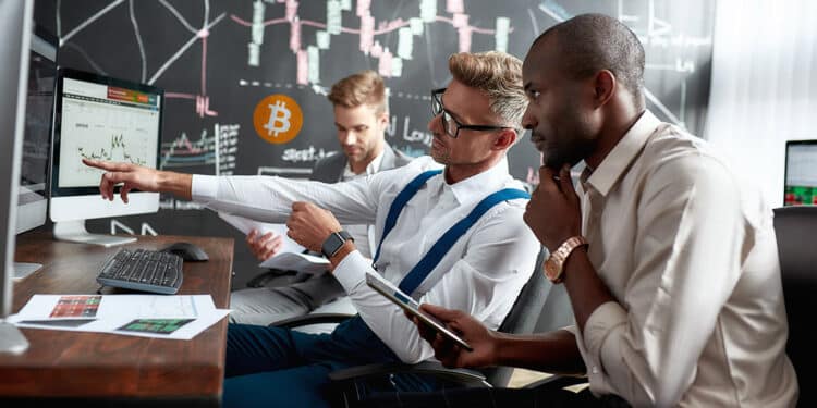 Analistas viendo el precio de bitcoin en alza.