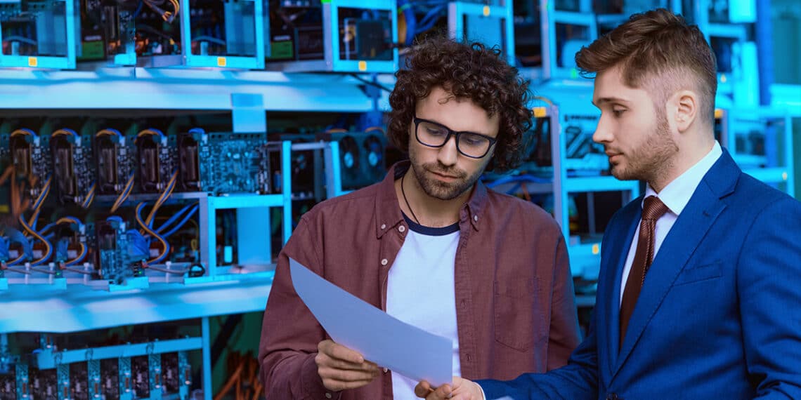 Hombres preocupados observando documentos con mineros de criptomonedas en el fondo