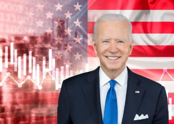 Biden, bandera de Estados Unidos y gráfico decreciente.