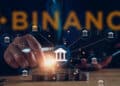 personas apilando monedas con bancos digitales conectados en red y logo de binance en el fondo