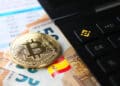 moneda de bitcoin sobre billetes de euros junto a calculadora con logo de bitcoin