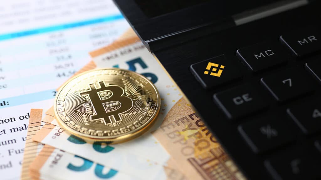 moneda de bitcoin sobre billetes de euros junto a calculadora con logo de bitcoin