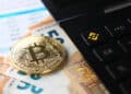 moneda de bitcoin sobre billetes de euros junto a calculadora con logo de bitcoin