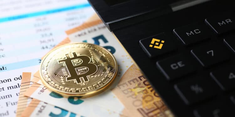 moneda de bitcoin sobre billetes de euros junto a calculadora con logo de bitcoin