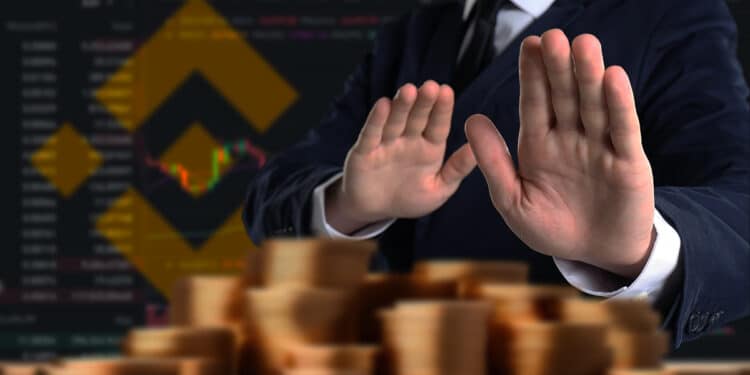 persona rechazando monedas apiladas con plataforma y logo de binance en el fondo
