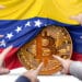 manos señalando moneda de bitcoin con bandera de venezuela