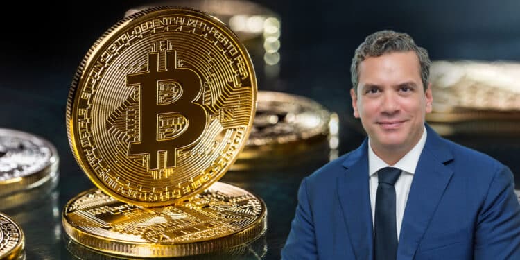 Hugo Ferrer con moneda de bitcoin en el fondo entre monedas sobre mesa