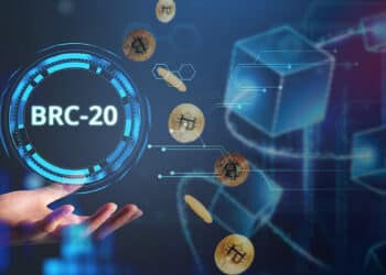 persona sosteniendo nft digital junto a monedas de bitcoin cayendo y cadena de bloques en el fondo