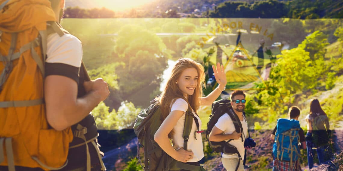 turistas en expedición al campo con banderra de El Salvador en el fondo