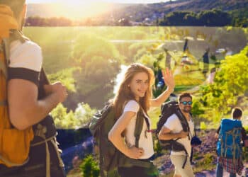 turistas en expedición al campo con banderra de El Salvador en el fondo
