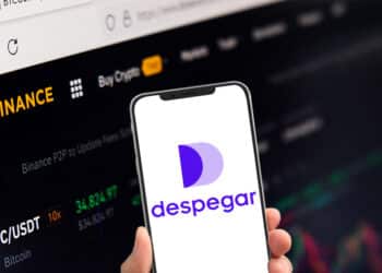 Celular con aplicación de despegar junto a plataforma de binance.