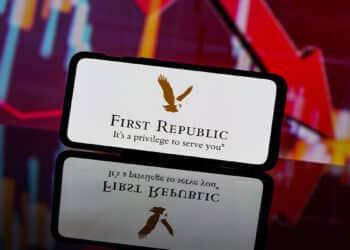 telefono movil con logo de first republic bank con graficos bajistas en el fondo