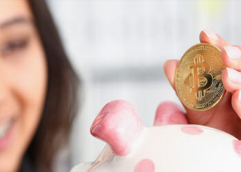 mujer depositando moneda de bitcoin en alcancía