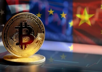 moneda de bitcoin sobre grafico de mercado en pantalla con banderas de Estados Unidos, Europa y China en el fondo