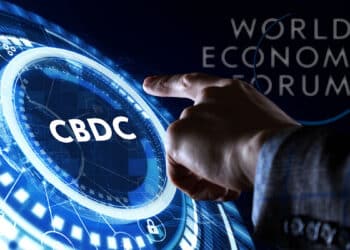mano seleccionando CBDC con logo del Foro Economico Mundial en el fondo