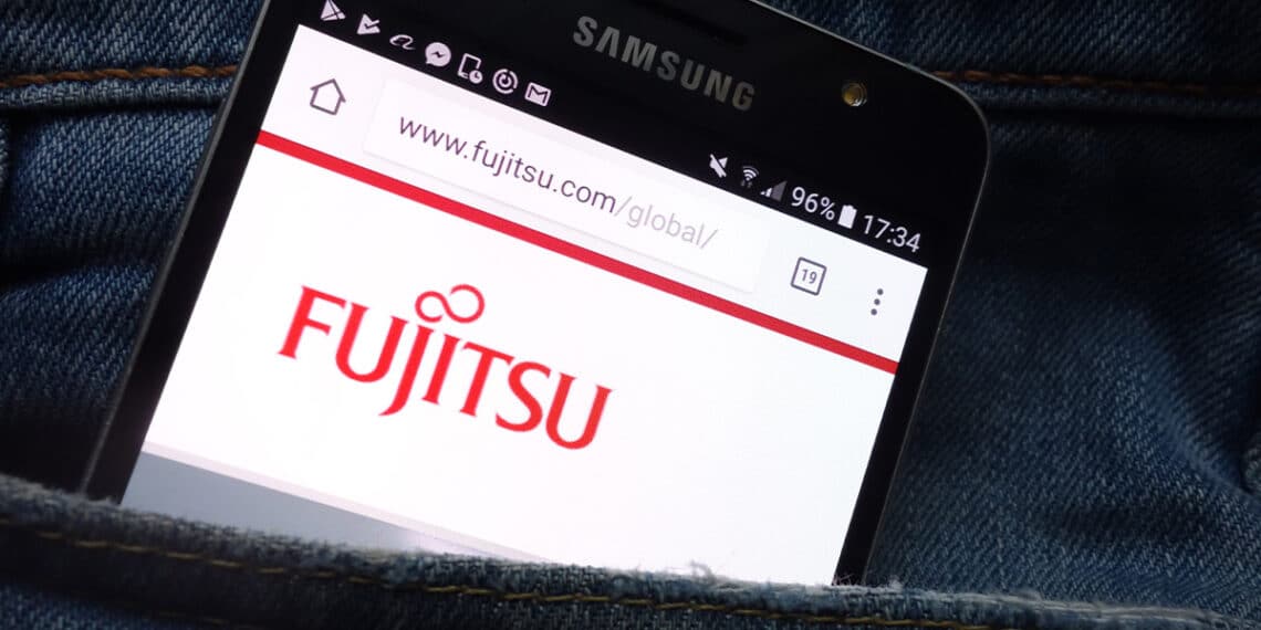 telefono movil en bolsillo de pantalon con página de fujitsu abierta en pantalla