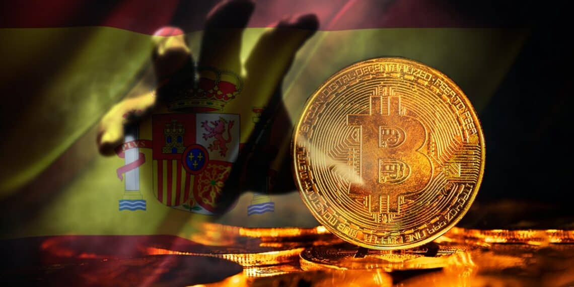 mano sombria acercandose a moneda de bitcoin con bandera de españa en el fondo