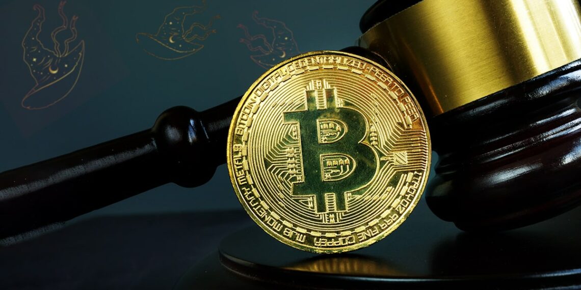 moneda de bitcoin apoyada en martillo de juez con sombreros de bruja en el fondo