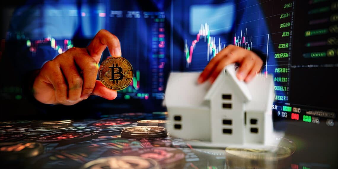 persona muestra moneda de bitcoin sosteniendo modelo de casa en miniatura con graficos de precio en el fondo