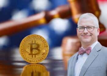 Representante Patrick McHenry con moneda de bitcoin sobre escritorio legal y bandera de Estados Unidos en el fondo