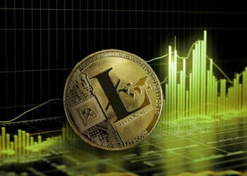 moneda de litecoin sobre superficie con grafico de precio en alza en el fondo