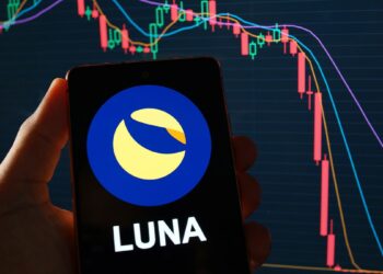 logo de Luna en telefono movil con grafico de precio bajista en el fondo