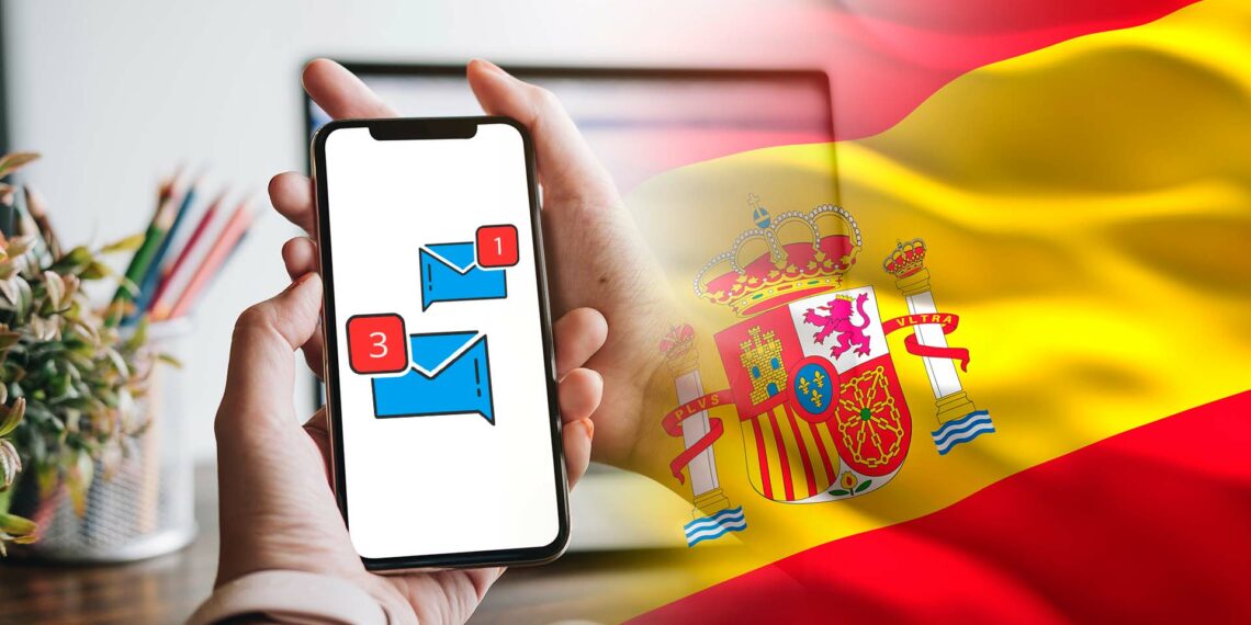 Bandera de España y celular con mensajes.