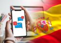 Bandera de España y celular con mensajes.