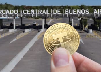 mano sostiendo moneda de tether con entrada al mercado Central de Buenos Aires en el fondo