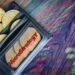 monedas de bitcoin dentro de billetera con logo de Microstrategy e indicadores de mercado reflejados sobre mesa