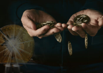 monedas de bitcoin cayendo de manos juntas con moneda de bitcoin dividiendose en el fondo