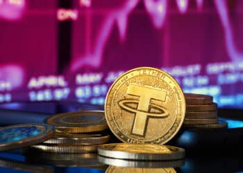 moneda de tether con grafico de mercado cambiando de color de rojo a azul en el fondo