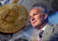 Peters Schiff con moneda de bitcoin sobre billetes de dólares en el fondo