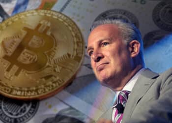 Peters Schiff con moneda de bitcoin sobre billetes de dólares en el fondo