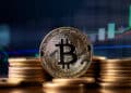 moneda de bitcoin entre monedas apiladas con grafico de precio ascendente en el fondo