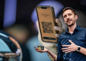Ricardo Macieira con imagen de worldcoin en el fondo