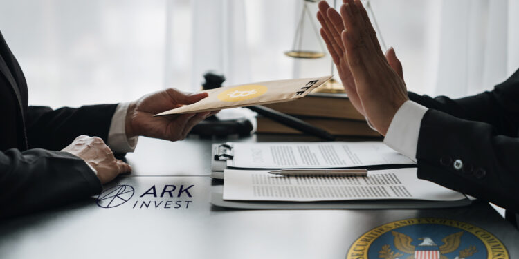 persona rechaza etf de bitcoin de ark invest con logo de la sec en la mesa