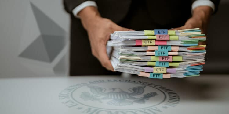 persona sosteniendo solicitudes de ETF sobre escritorio con logo de la SEC y logo de ethereum en el fondo